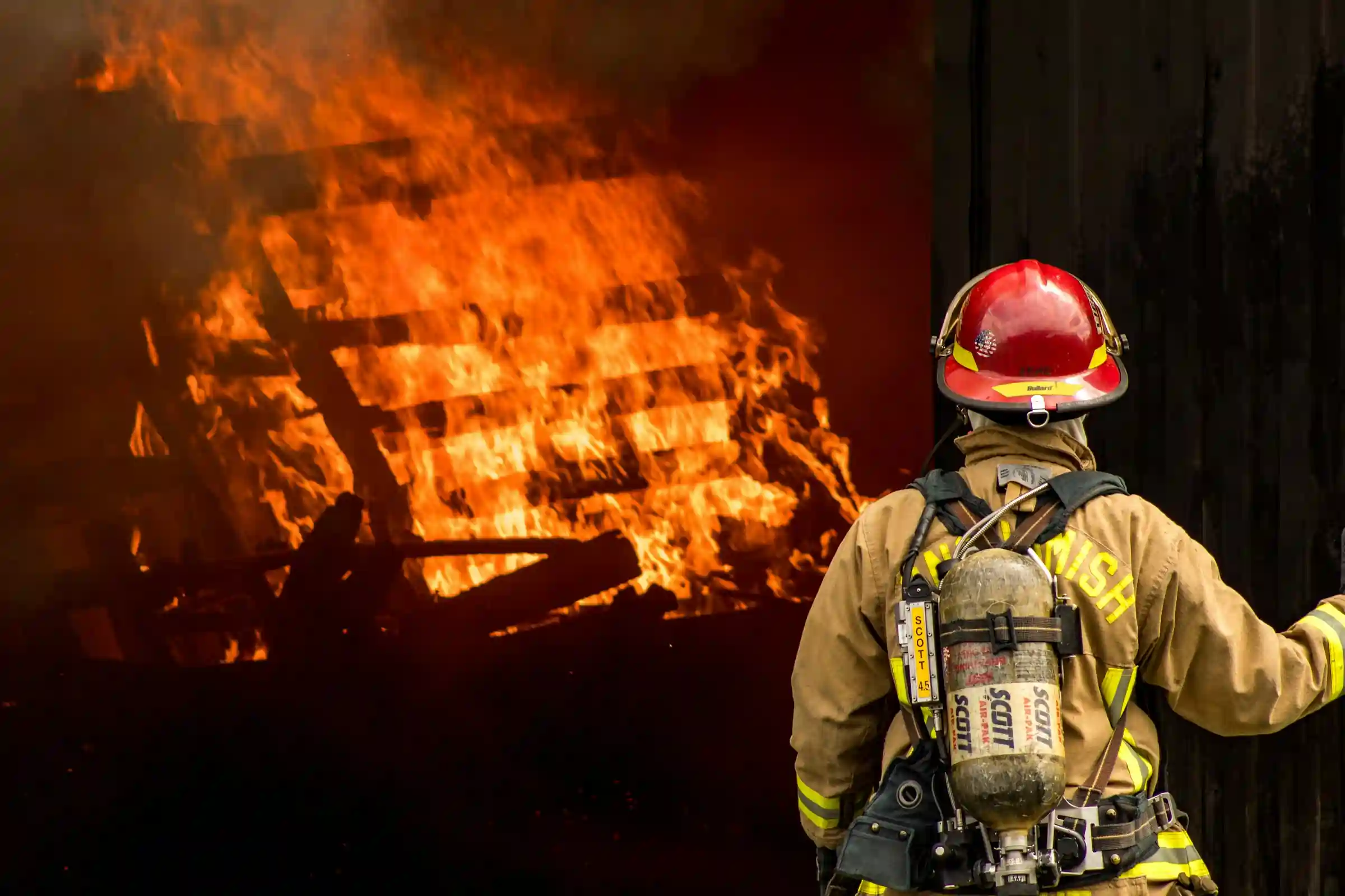 Ugniagesys gelbėtojas gesinantis gaisrą.
