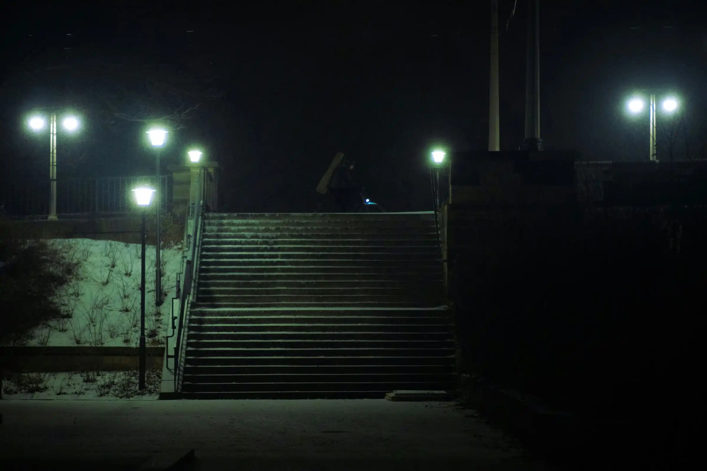 Nakties metu, gatvės žibintų apšviesti laiptai.
