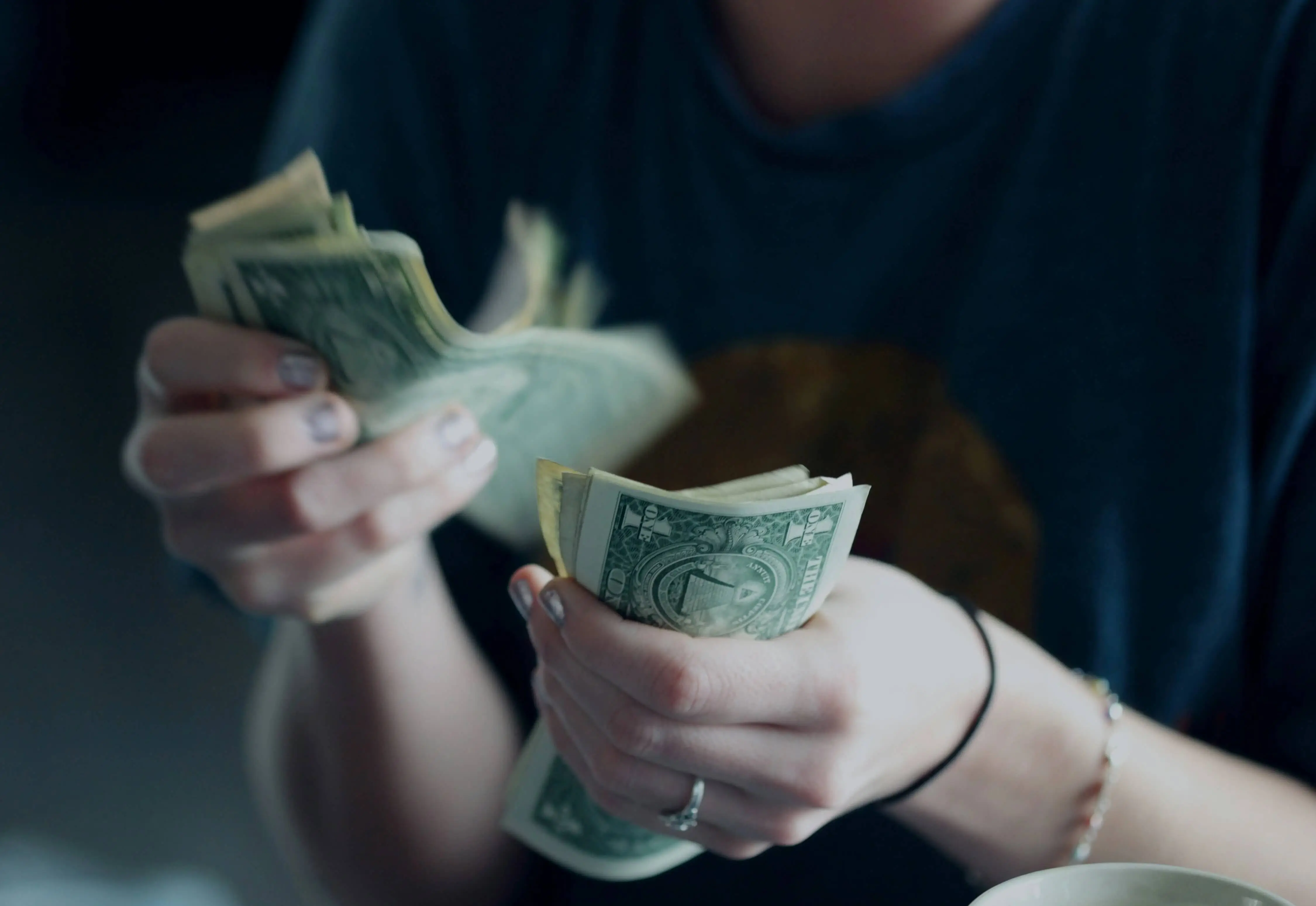 Moteris laikanti pinigus rankose
